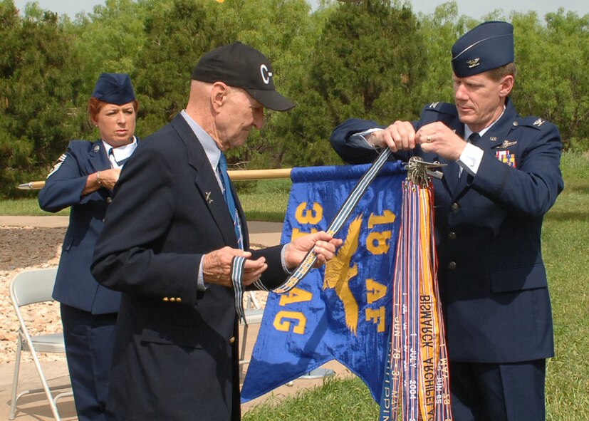 Retired Col. Gail Halvorsen, former C-47 and C-54 pilot with the 317th Troop Carrier Group, now known as the 317th Airlift Group, attaches The Berlin Airlift Streamer to the 317th AG guidon on behalf of SECAF during a ceremony here May 3. Colonel Kevin Jackson, 317th AG commander, and Chief Master Sgt. Debra Huntley, 317th AG acting command chief, assisted in the ceremony. The work the 317th AG did in 1948 and 1949 was similar to the work they do now in the Global War on Terror. (U.S. Air Force photo by: Airman 1st Class Felicia Juenke)