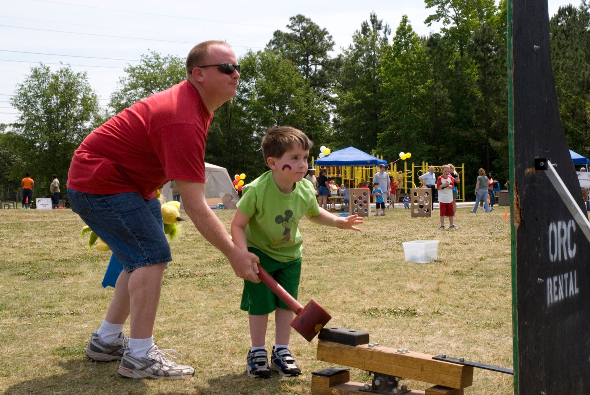 Jonathan Coffing, 5, gets a little help from his father, Staff Sgt. Cary Coffing, 437th Logistics Readiness Squadron, with the hammer strike game at the Month of the Military Child Festival on base, April 28. (U.S. Air Force photo/Airman Melissa Harper)