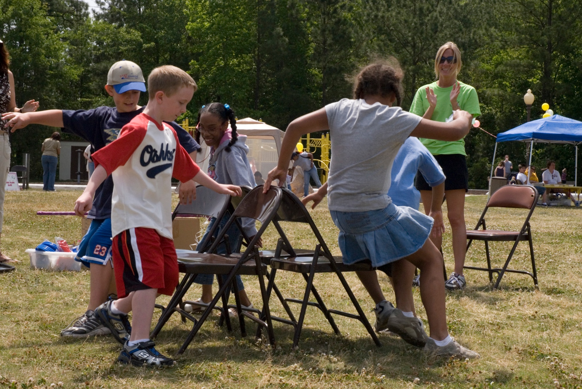 Team Charleston children participate in a game of musical chairs while Shannon Norris, Youth Programs director, watches. (U.S. Air Force photo/Airman Melissa Harper)