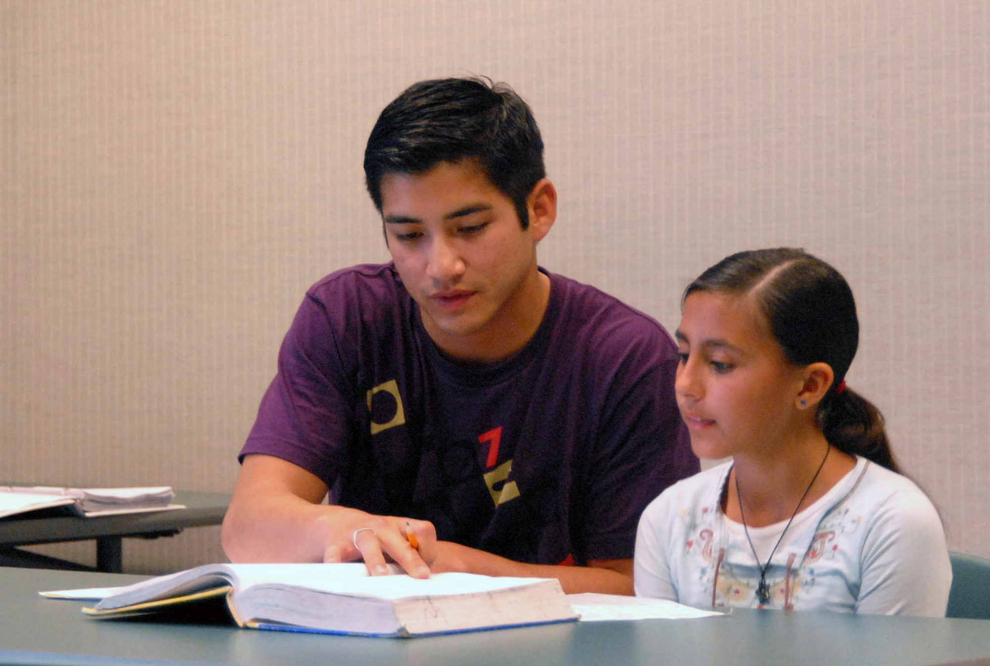 Second Lt. Patrick Leary, 412th Test Support Squadron acquisition manager, helps Vanessa Olmos, a local student, with her mathematics homework May 5. About 20 Edwards company grade officers volunteer their time and effort at the Wanda Kirk Rosamond Library to help children prepare for math tests, homework and make-up work. (Photo by Airman Mike Young)