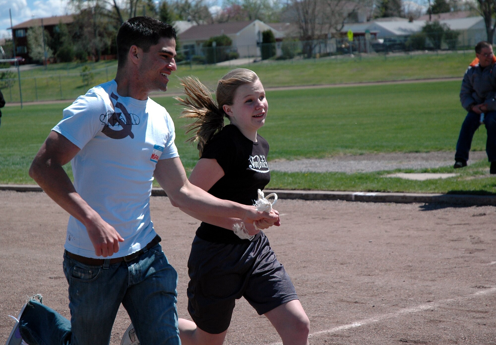 Airman 1st Class Mark Ackley runs with Montana School for the Deaf and Blind student, Lauren, during the Games for the Visually Impaired Friday. About 70 members of the Security Forces Group volunteered Friday and Saturday to help students participate in the games. (U.S. Air Force photo / Valerie Mullett)
