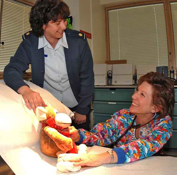 Maj. Kerin McKellar, officer in charge of pediatrics at the 377th Medical Group, and Elizabeth Cook, pediatrics nurse practitioner, discuss using a stuffed animal at the pediatric clinic.  The medical group is paying tribute to nurses during , which ends May 12.  U.S. Air Force photo by Adam Wooten