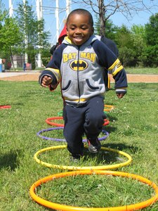 Joseph Simmons, son of Staff Sgt. Temeka Simmons, a mission capability technician for the Combat Air Force Logistics Support Center, jumps through hoops at the Russ Child Development Center during the Hop-a-thon May 4. The center provided several activities for children, including potato sack races , hopscotch, leapfrog and alphabet hopping. (U.S. Air Force photo/Amy L. Robinson)