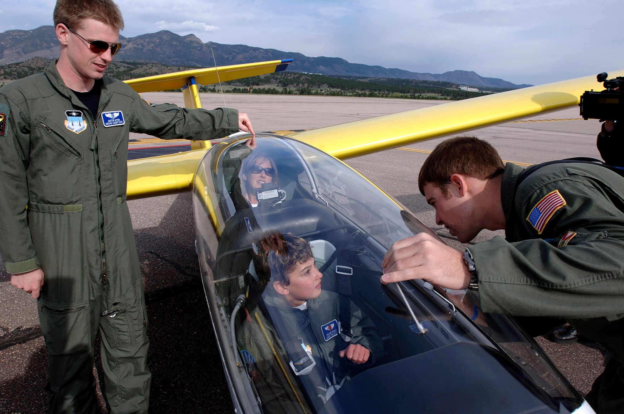 Sophomore cadets Justin Wynn and Erik Gonsalves talk to 10-year-old Julian Willis and his mom JoAnne Willis about an Academy glider on the flightline at the U.S Air Force Academy, Colo. The Make-a-Wish Foundation and the Air Force Academy made Julian a "Cadet for a Day". Cadets have sponsored 22 children since the program started in 2000. (U.S. Air Force photo/Mike Kaplan)