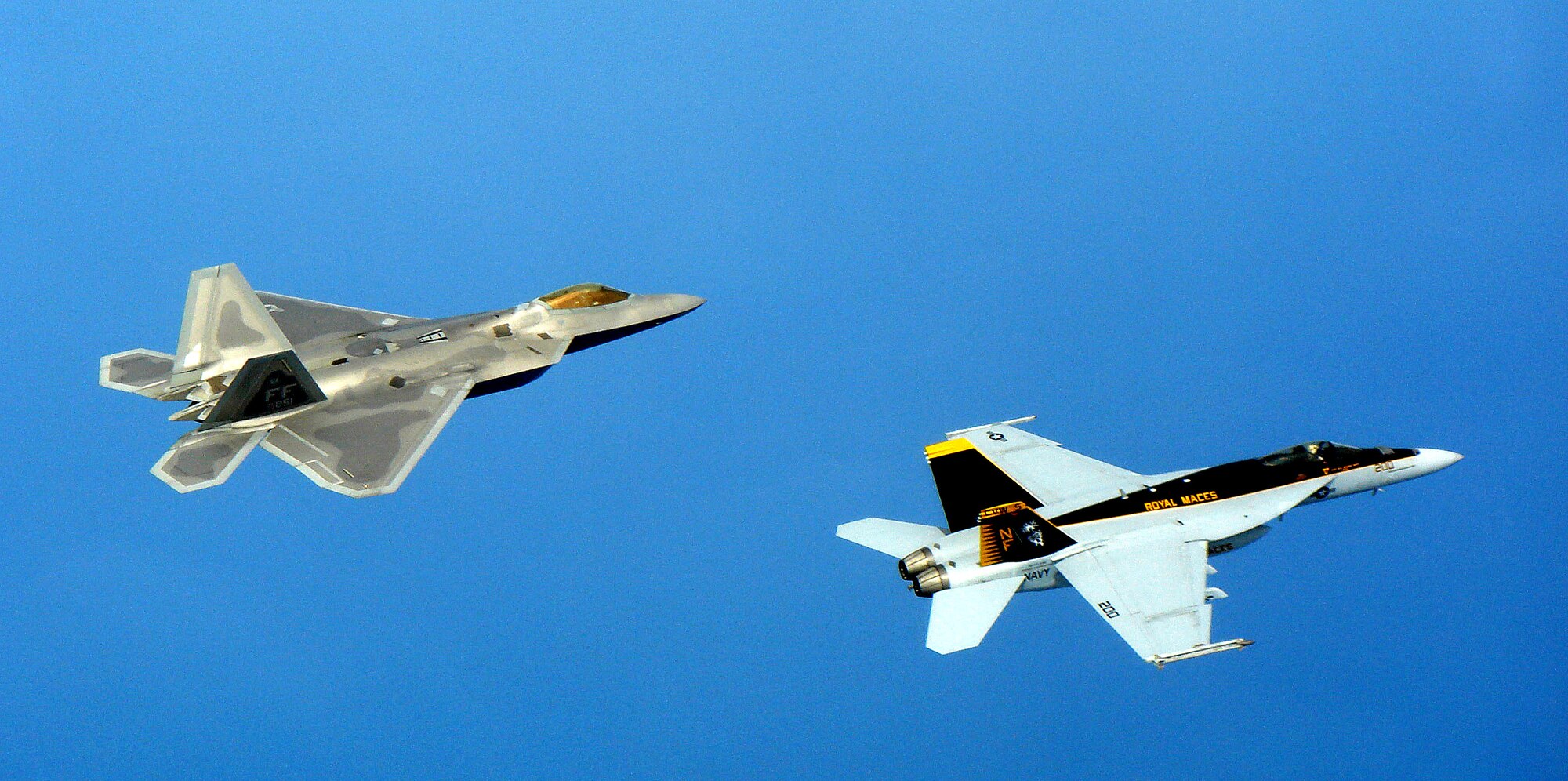 An F-22A Raptor deployed to Kadena Air Base, Japan, trains with a U.S. Navy F/A-18 Super Hornet April 26, near Okinawa, Japan. The Raptors, from the 27th Fighter Squadron, at Langley Air Force Base, Va., deployed to Kadena in February. The Super Hornets, the Navy's newest frontline carrier-based fighter, are stationed at Naval Air Facility Atsugi, Japan. The training exercises focused on the next generation fighter capabilities between the two aircraft. (U.S. Navy photo/Christopher Hurst)