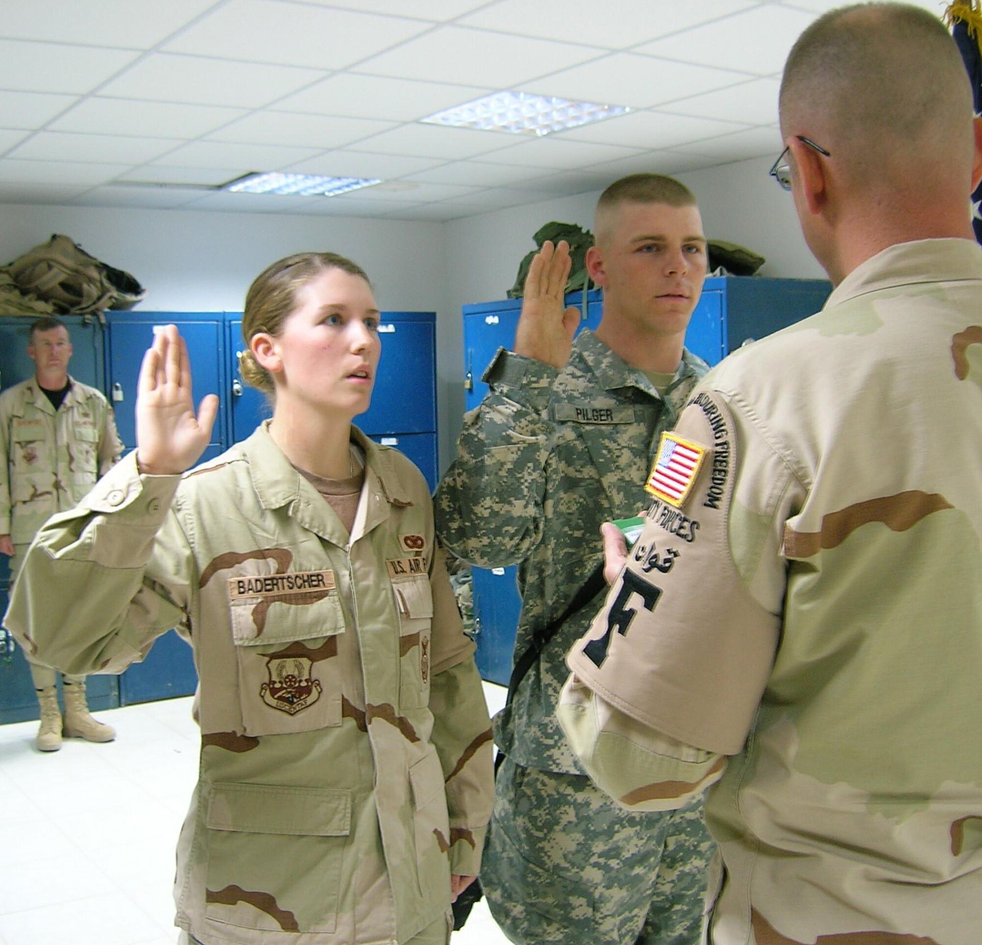 Together, Senior Airman Cora Badertscher, 31st Security Forces Squadron, and her brother, Army Sgt. Jerron Pilger, take the oath of enlistment given by Capt. Jon Eckert, 332nd Expeditionary Security Forces Squadron, at Balad Air Base, Iraq. Airman Badertscher is deployed to the 332nd ESFS at Balad and Sergeant Pilger is deployed to Baghdad, Iraq. (Courtesy photo) 