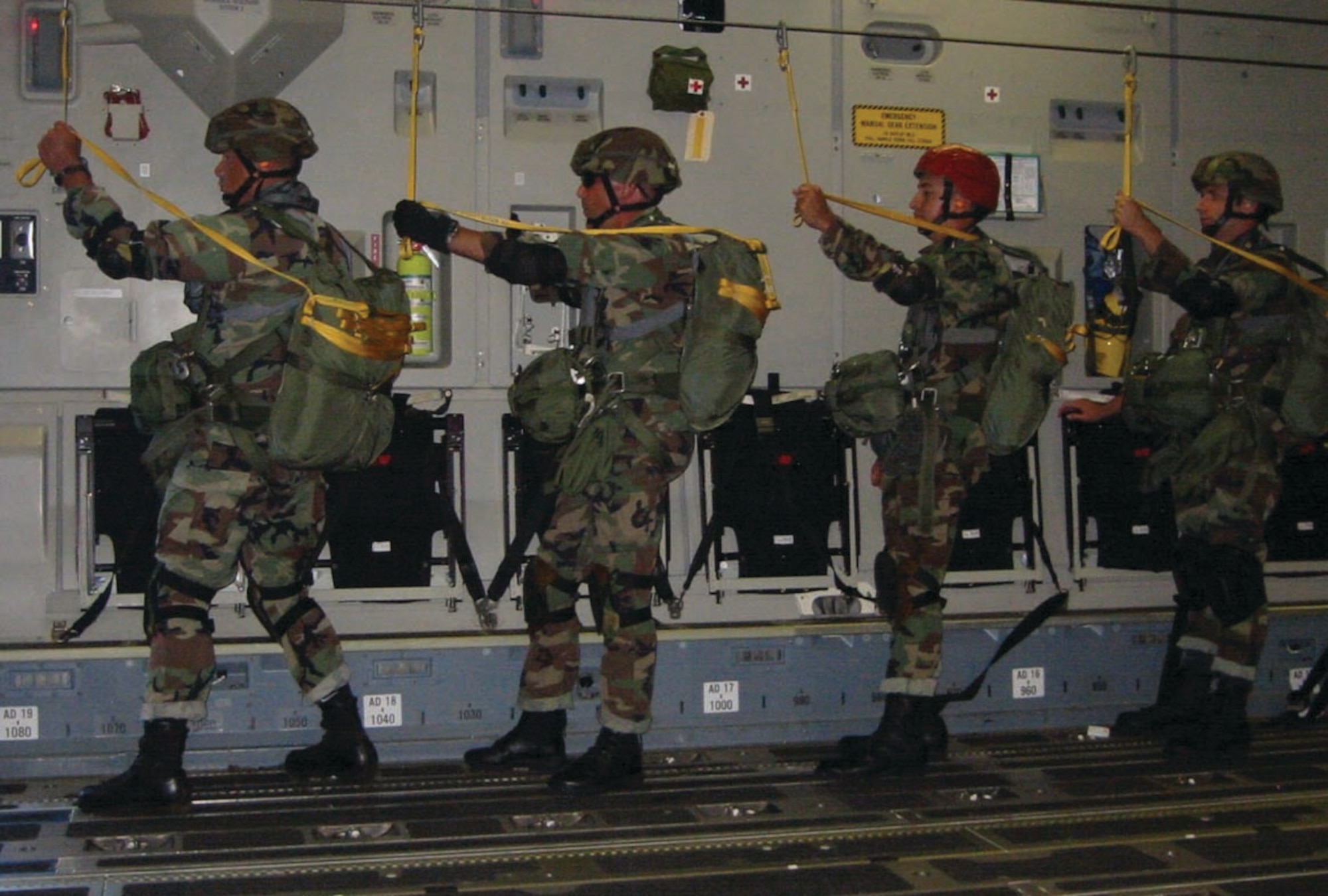 Four 36th Contingency Response Group Airman stand ready to parachute from a C-17.  
