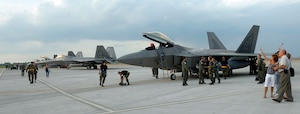 Members of the 27th Fighter Squadron are greeted as they return from the Raptor’s first overseas deployment May 11. The F-22s flew nearly 700 sorties with joint and coalition forces at Kadena Air Base, Japan, as part of the three-month deployment. (U.S. Air Force photo/Airman 1st Class Vernon Young)