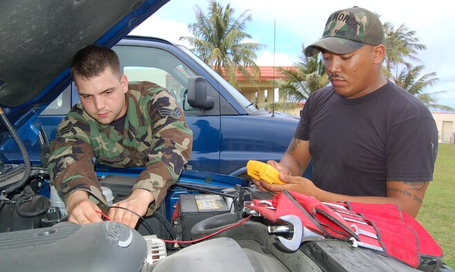 Senior Airman Edward Watkins and Staff Sgt. Tavis Salas, 554 RED HORSE Squadron vehicle maintenance technicians, trouble shooting alternator flow of a squadron vehicle during routine maintenance. 