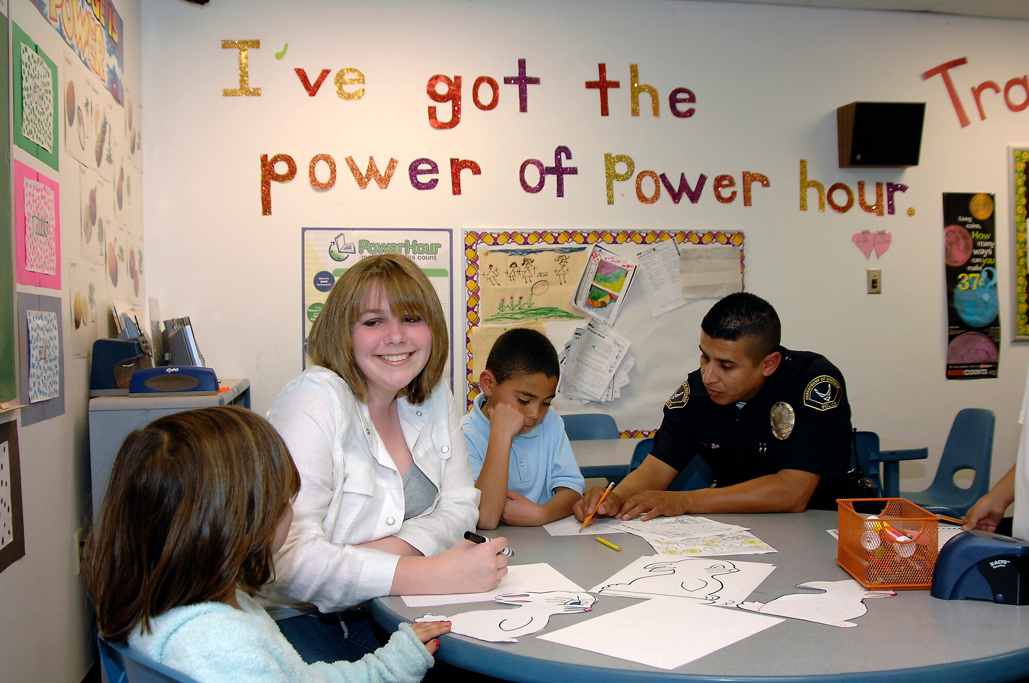 Ariel Hawkins, AFSPC Youth of the Year for two years in a row, volunteers with base children. Pictured from left to right are Maddie Clausen, daughter Lt. Col Robert and Maureen Clausen; Ariel Hawkins;  Wilfred Roldan, son of E-6 Oscar and Madeline Roldan; and Officer Jose Barragan, DARE Program.
