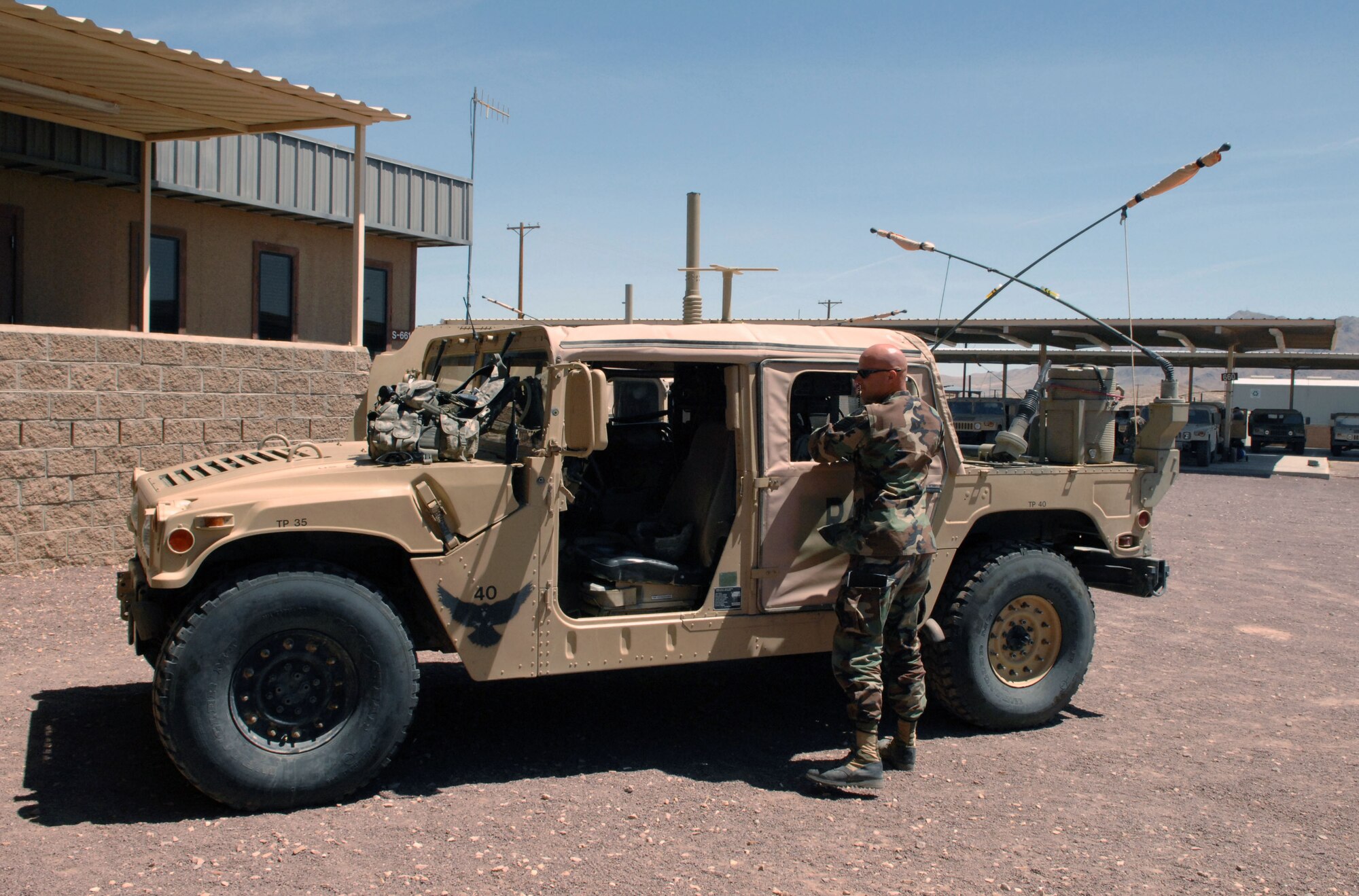 Tech. Sgt. Frank Loftin prepares his hummer for a mission during a National Training Center and Green Flag exercise May 2 at Fort Irwin, Calif. Sergeant Loftin is an observer/controller Joint Terminal Attack Controller assigned to the 12th Combat Support Squadron at Fort Irwin. His job is to help prepare JTACs and aircrews prior to their deployments.  (U.S. Air Force photo by Staff Sgt. Jeremy Smith)                       