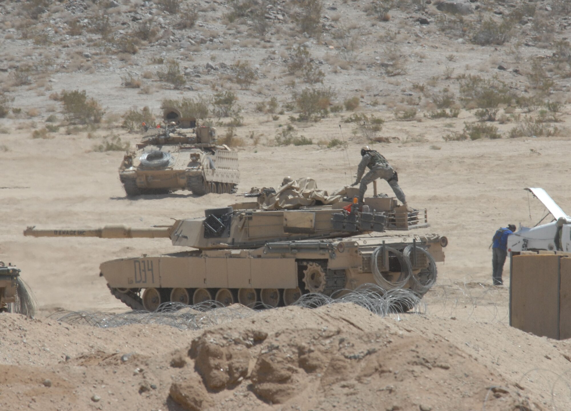 An Army Soldier sets up a tarp over his tank to protect against the dust and wind during an exercise at the National Training Center at Fort Irwin, Calif.  The two-week exercise is designed to replicate one year's worth of combat scenarios to prepare Soldiers and Airmen for the Global War on Terrorism. (U.S. Air Force photo by Staff Sgt. Jeremy Smith)