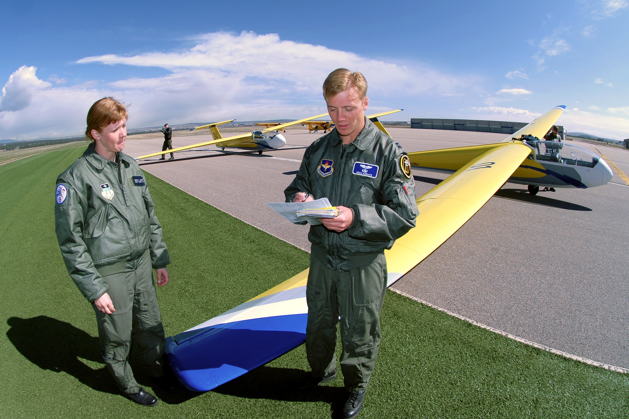 Capt. Erich Kunrath, an instructor pilot with the 94th Flying Training Squadron, reviews a grade card with basic soaring student, Sophomore Samantha Saenger, after a training sortie at the U.S Air Force Academy, Colo. The 94th FTS conducts more than 15,000 training and competition glider sorties annually, focused on developing the leadership and character of more than 4,000 USAFA and ROTC cadets. (U.S. Air Force photo/David Armer)