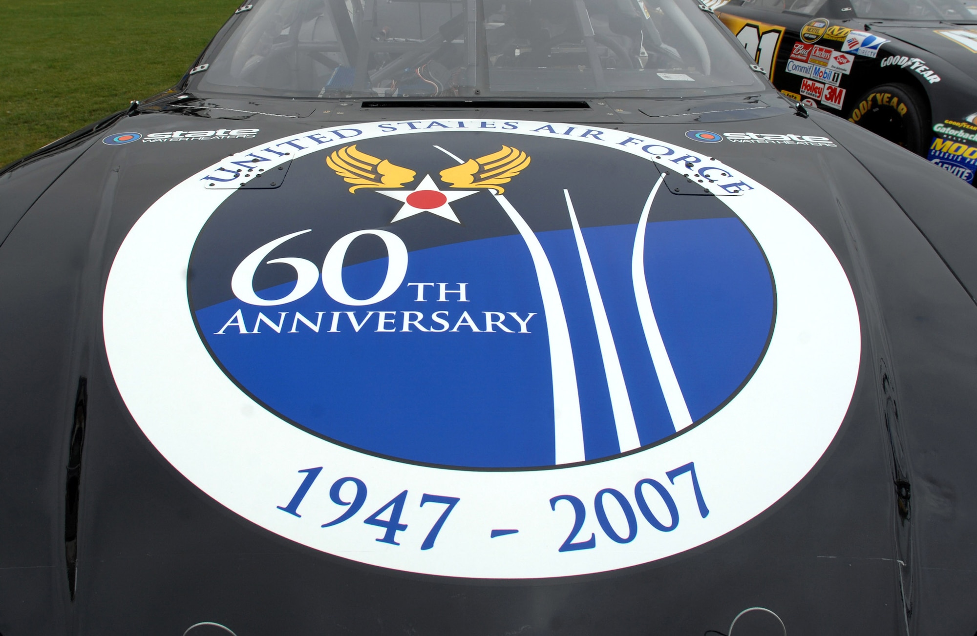 The U.S. Air Force 60th anniversary logo is unveiled on the hood of NASCAR driver Ward Burton's State Water Heaters car during an unveiling ceremony May 8 at Lowe's Motor Speedway in Charlotte, N.C. The unveiling was in recognition of "American Heroes Memorial Day Salute to the Armed Forces". (Department of Defense photo/William D. Moss)