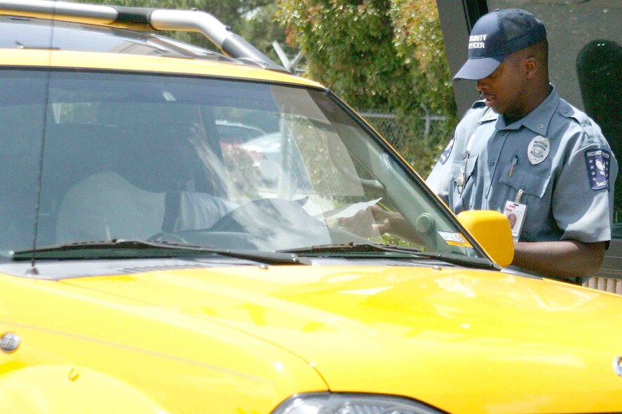 SHAW AIR FORCE BASE, S.C. -- Sergeant Fredrick Barnes, a security officer, hands out a flyer May 11 at the Sycamore Gate. The flyer discusses the reduced operating hours at the gate, which start May 14. The two main reasons for the reduction in hours are lack of manpower due to deployments and the need to enhance security.  (U.S. Air Force photo/Senior Airman John Gordinier)