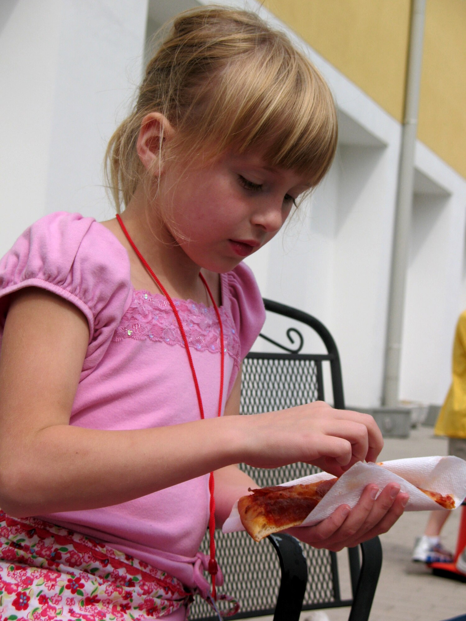 First-grader Julian George enjoys a slice of pizza at the final meeting of Aviano's Elementary School Deployment Club.  While the children ate their pizza, they talked with other children who had a parent deployed. The club is a means for the children of deployed Aviano Airmen to interact with one another. (U.S. Air Force photo/Airman 1st Class Justin Goodrich)
