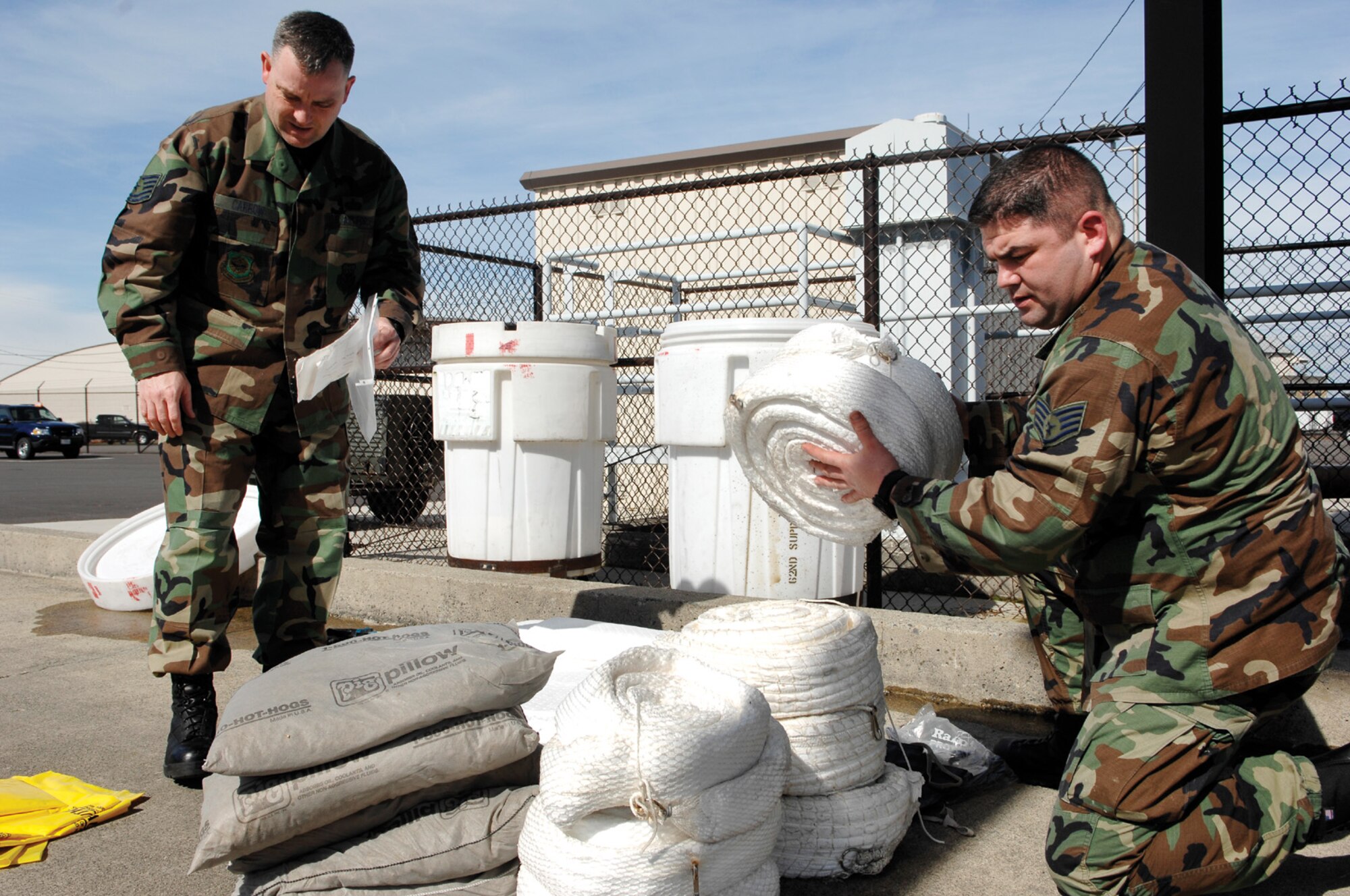 MCCHORD AIR FORCE BASE, Wash. -- Tech. Sgt. Greg Carrow, left, and Staff Sgt. Joseph Pinkham, both from the 62nd Logistics Readiness Squadron inspect a fuel spill response kit to insure Airmen have inventoried and properly stored items needed in the event of an emergency. (U.S. Air Force photo/Abner Guzman)