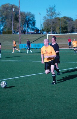 MCCHORD AIR FORCE BASE, Wash. -- Halfback Shawn Lizotte, 62nd Communications Squadron, dribbles the ball downfield with Mike Tenbusch, 62nd Security Forces Squadron, in pursuit. SFS got two early goals from Chad Prime and held on to defeat COMM 2-1 Monday night at Rainier Field. (U.S. Air Force photo/Tyler Hemstreet)
