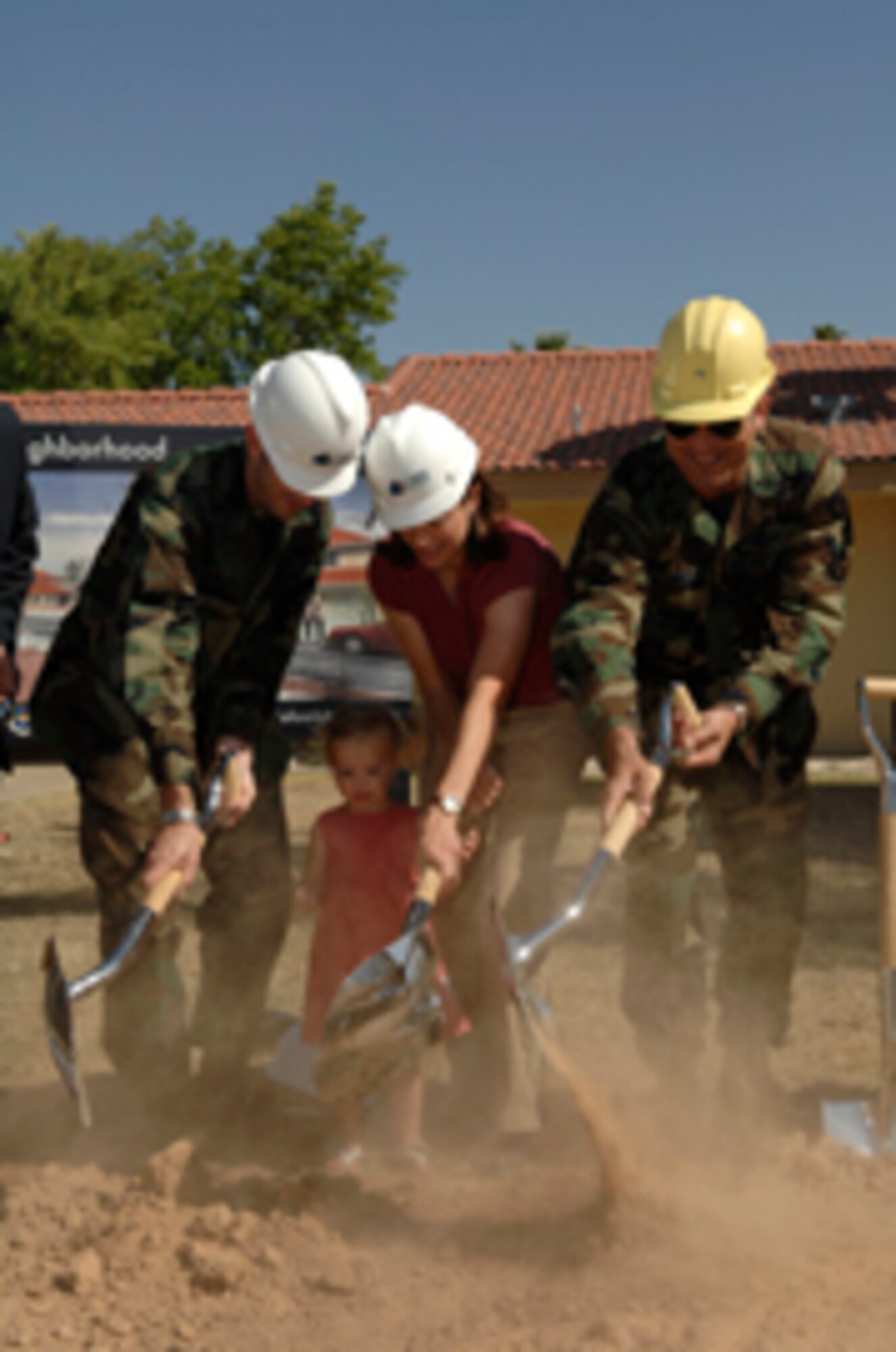 From left: 1st Lt. Imie Mark, 56th Maintenance Group executive officer; wife, Amy; daughter, Mary Kate, 3; and Brig. Gen. Tom Jones, 56th Fighter Wing commander,
participate in a ground breaking ceremony May 3 on a $49 million residential project to provide new military family housing on Luke. General Jones also drove the claw of
an excavator through the roof of one of the older homes being demolished. A contract calls for GMH Military Housing to develop and oversee all existing and new
family housing at Luke for the next 50 years. (Photo by Master Sgt. William Gomez)