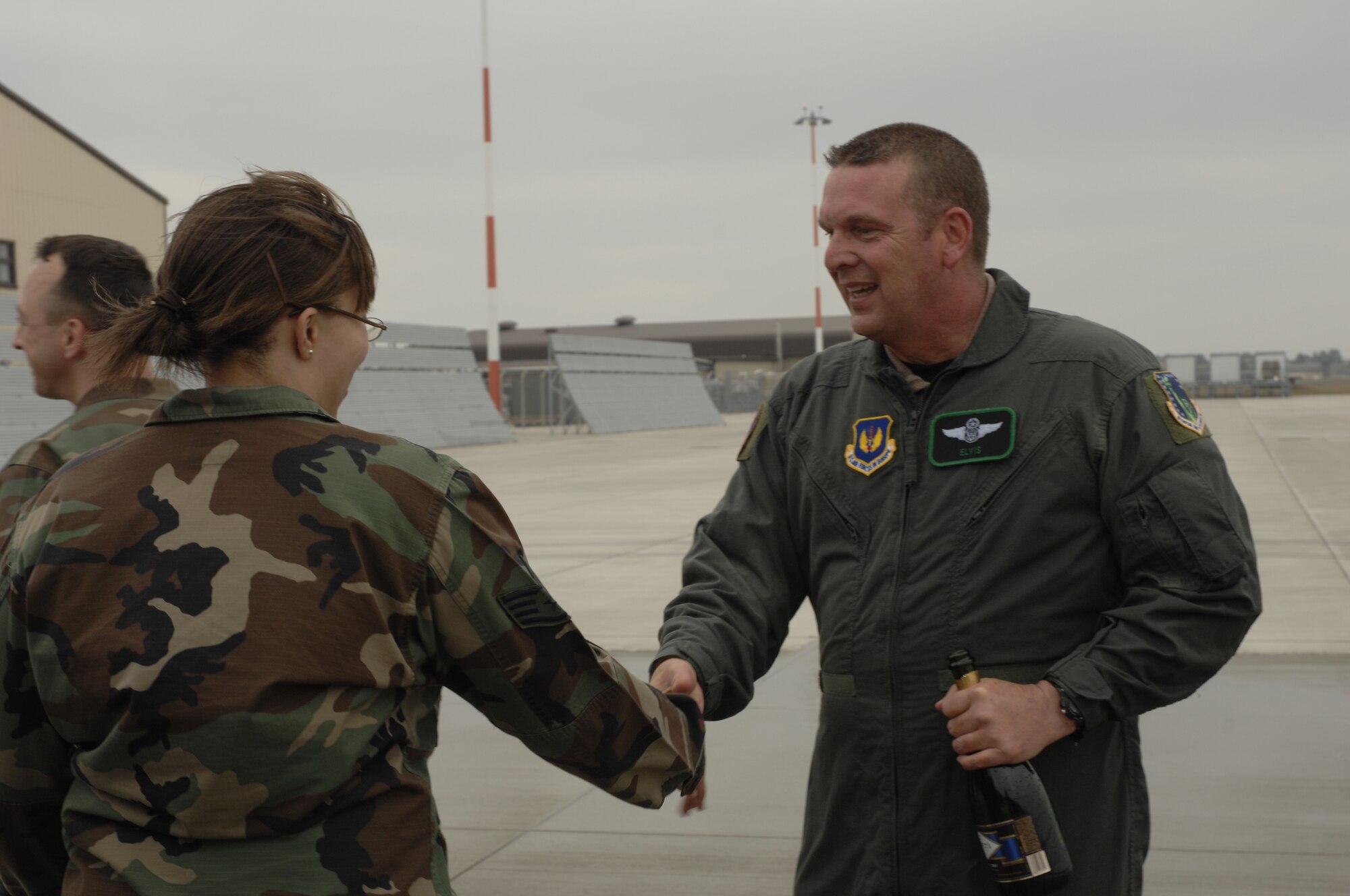 A soaking wet Command Chief Master Sgt. Jerry K. Sutton shakes hands with Staff Sgt. Jonica Parker, 48th Component Maintenance Squadron May 3 after his fini flight at RAF Lakenheath. Chief Sutton flew in a HH-60 Pavehawk for his fini flight and was hosed down by the Liberty 56. (U.S. Air Force photo by Airman 1st Class Jessica Snow)