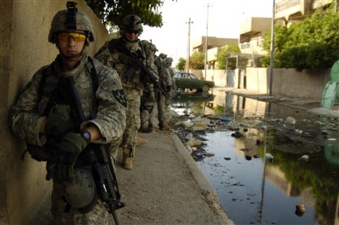 U.S. Army soldiers take defensive positions outside a house during a cordon and search mission in Al Risalah, Iraq, on May 8, 2007.  The soldiers are assigned to Alpha Company, 2nd Battalion, 3rd Infantry Regiment, 3rd Stryker Brigade Combat Team, 2nd Infantry Division.  