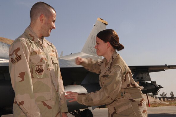 BALAD AIR BASE, Iraq - Senior Airman Kevin Reilly, 332nd Expeditionary Aircraft Maintenance Squadron, has his stripes tacked on by his sister, 1st Lt. Erin Reilly, 506th Expeditionary Logistics Readiness Squadron. Lt. Reilly flew to Balad Air Base May 8 from Kirkuk Regional Air Base, Iraq, to surprise her little brother on his proomotion day to senior airman below-the-zone. (U.S. Air Force photo/Staff Sgt. Michael R. Holzworth)