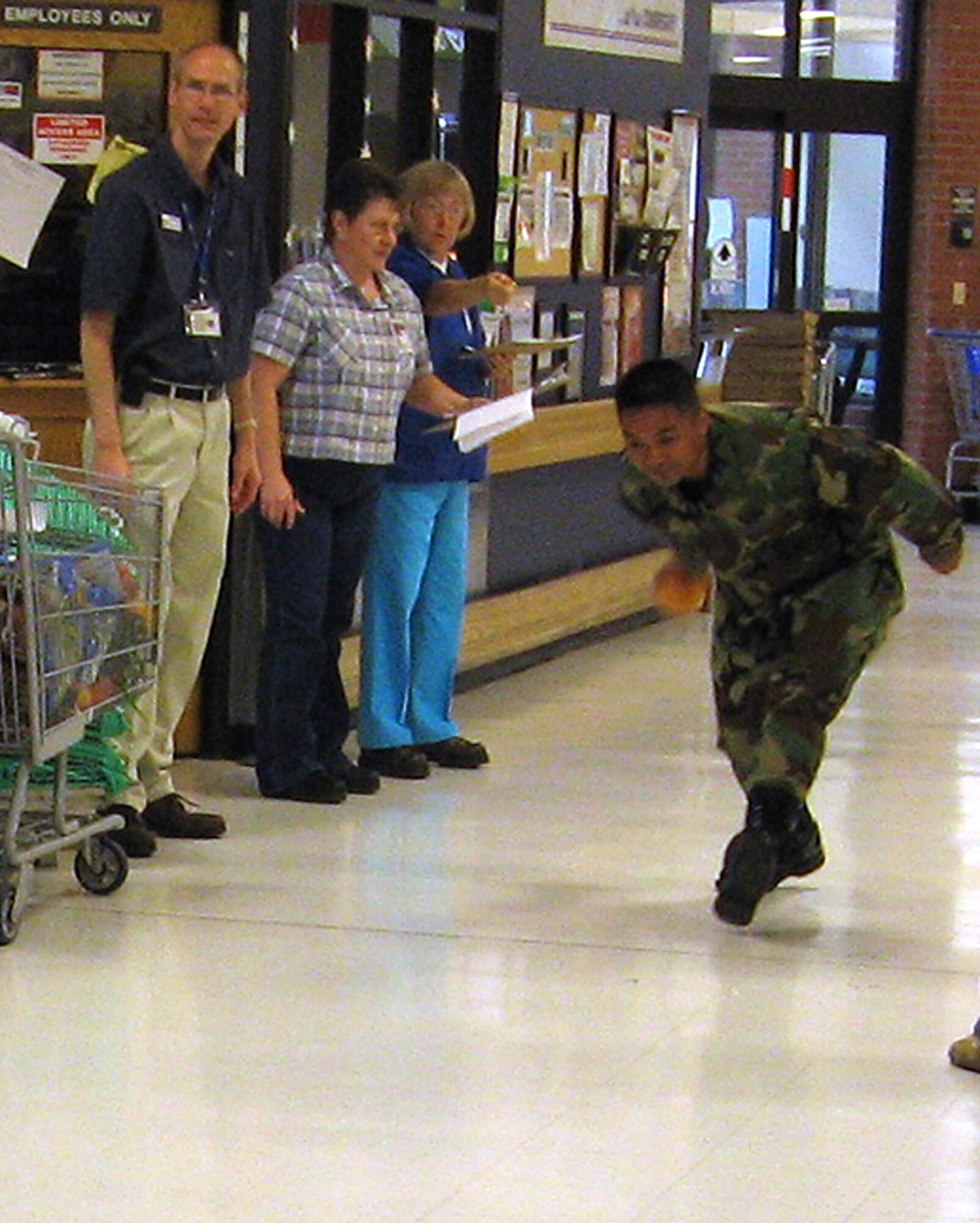 FAIRCHILD AIR FORCE BASE, Wash. -- Tech. Sgt. Eliseo Dumlao, First Term Airmen Center NCOIC, winds up to pitch a grapefruit during a commissary-style bowling competition in which the Airmen had to bowl down rolls of paper towels with the fruit. This was one of the competitive events held during the Commissary Awareness Month challenge May 10. (Photo by Twila Bedwell)
