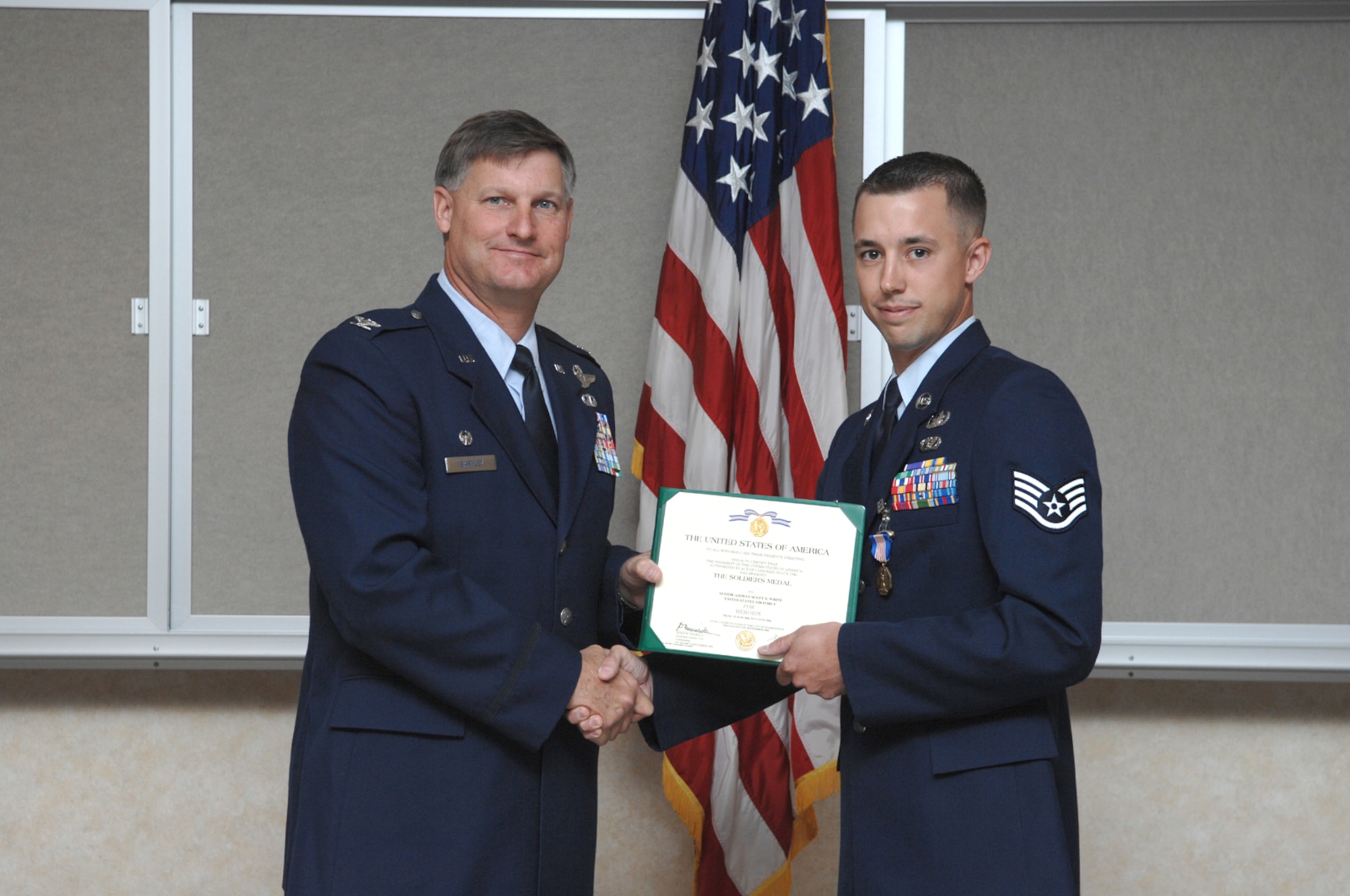 Col. Michael Bartley, commander, 99th Air Base Wing, awards Staff Sgt. Scott B. White (right) with the U.S Army Soldier's Medal on May 10, 2007, at Nellis AFB, Nevada.  Sergeant White is an explosive ordnance disposal technician assigned to the 99th Civil Engineering Squadron's EOD Flight.
(U.S Air Force Photo by: Airman 1st Class Nadine Barclay)