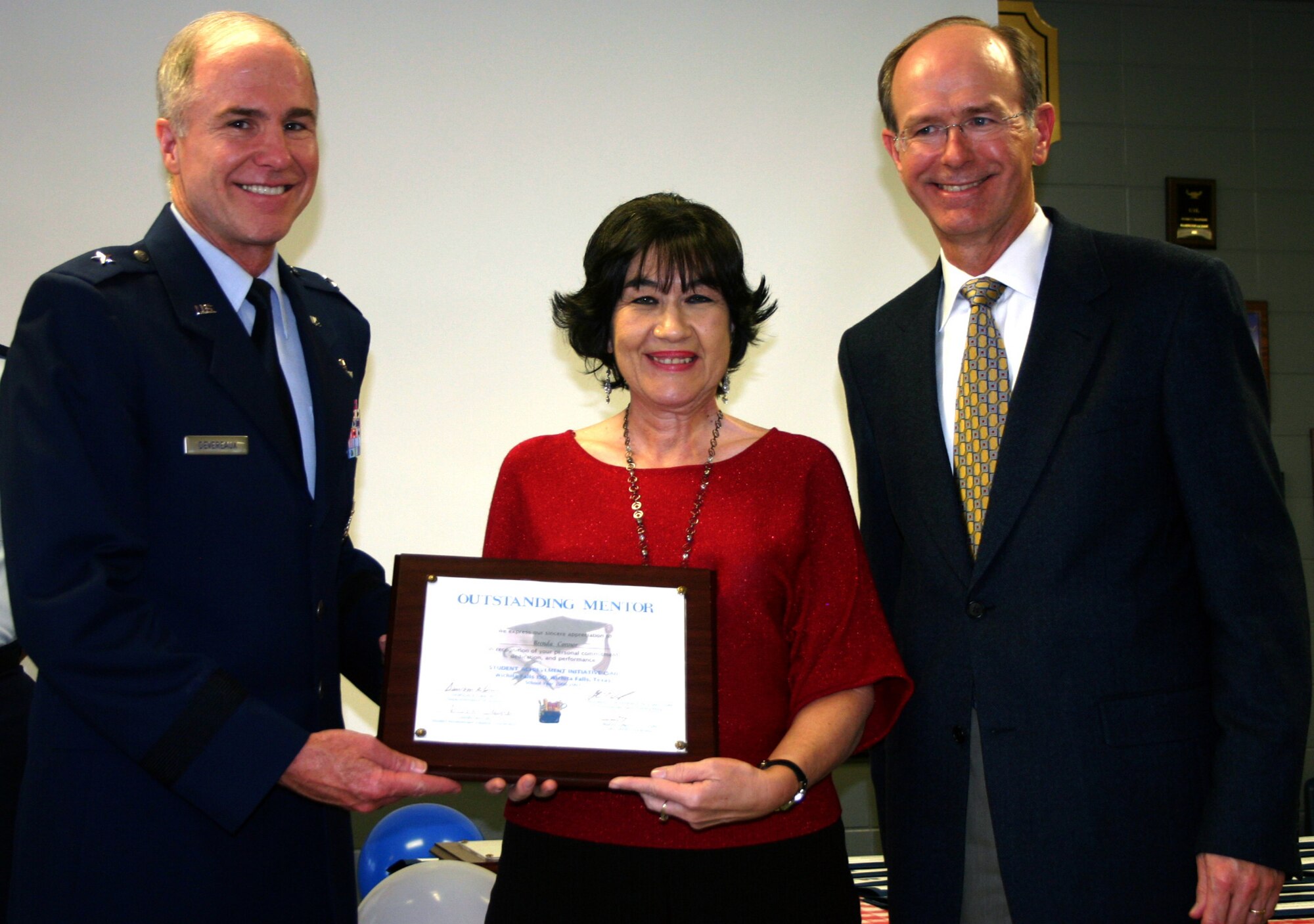 82nd Training Wing Commander Brig. Gen. Richard Devereaux and Wichita Falls Independent School District superintendent Dr. Dawson Orr present an Outstanding Mentor plaque to Brenda Connor, 383rd Training Squadron, in a ceremony at Washington-Jackson Elementary School May 10. Ms. Connor does volunteer work with the Student Achievement Initiative.  (U.S. Air Force photo/Staff Sgt. Tonnette Thompson)