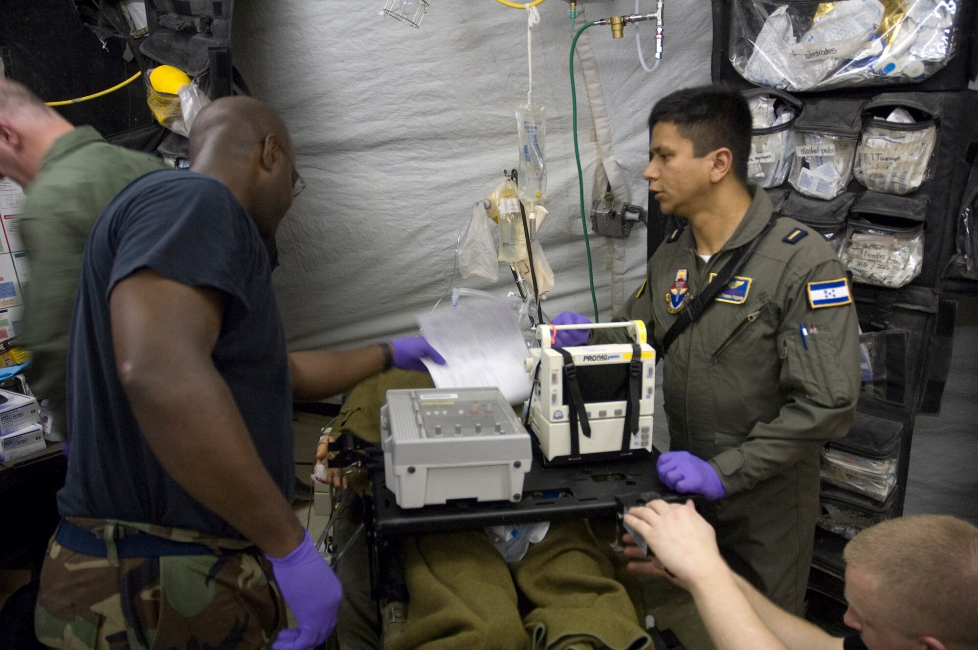 Dr. Pavel Perseo Fajardo, a flight surgeon from Honduras, along with members of his assigned Critical Care Air Transport Team, prepare a simulated patient for transportation from the Expeditionary Medical Facilty to the C-130 simulator at Brooks City-Base.  (U.S. Air Force photo/Steve Thurow)