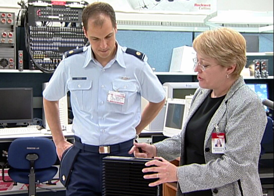 Maj. Daniel Cozzi talks with Rebecca Morrison about the Comprehensive Combat Flight Information System during a demonstration for the system in October 2006 at Rockwell's aviation laboratory in Cedar Rapids, Iowa. Ms. Morrison is a systems engineer for Rockwell Collins International, Inc. Major Cozzi is the project officer for the battlelab initiative Air Mobility Battlelab assigned to the Air Force Expeditionary Center at Fort Dix, N.J. (U.S. Air Force photo) 