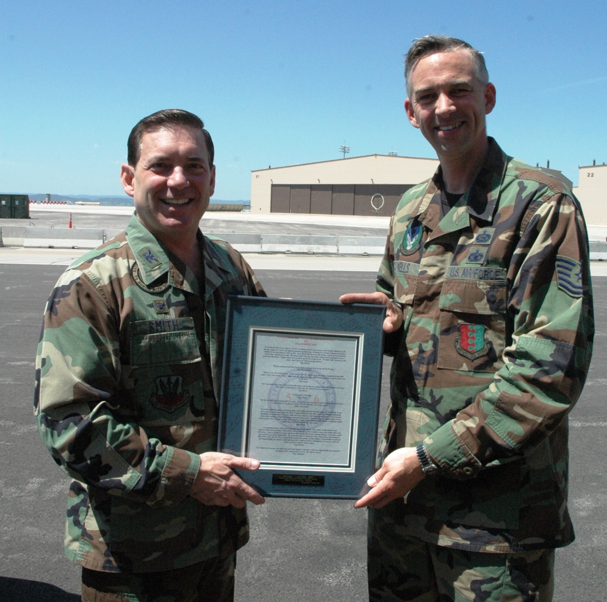 Col. Jeffry Smith, 28th Bomb Wing commander accepts a token of appreciation from Tech. Sgt. David Wells, 28th Bomb Wing Group 5/6 president during a junior enlisted farewell luncheon held here May 11.  The Ellsworth Group 5/6 sponsored the event in honor of Col. Smith's past 2 years as the bomb wing commander.  Col. Smith will turn over the wing to Col. Scott Vander Hamm during a change of command ceremony on June 1. (U.S. Air Force photo/Tech. Sgt. Todd Wivell)