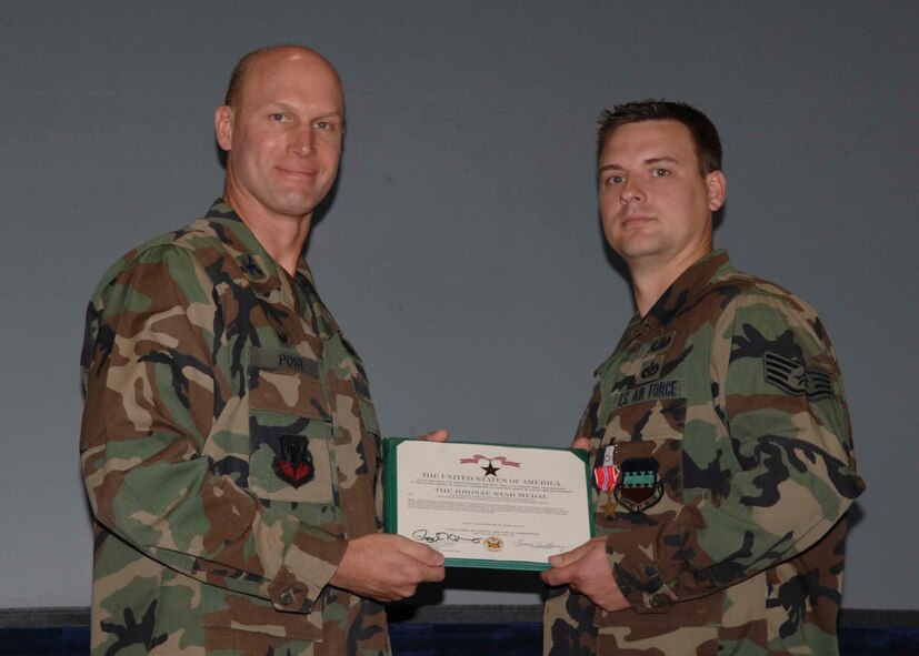 SHAW AIR FORCE BASE, S.C.-- Col. James Post, 20th Fighter Wing commander, presents Staff Sgt. Joshua Milligan, 20th Civil Engineer Squadron explosive ordinance disposal technician, a Bronze Star May 11 in hangar 1200 during a commander's call. The bronze star is awarded to servicemembers who distinguished them self by heroic or meritorious achievement or service. Sergeant Milligan received the medal for his excellence as an EOD team leader, while deployed to Iraq. His leadership was critical to the successful implementation of U.S. Central Command’s counter insurgent operations as well as ensured freedom of movement throughout areas of operation. Sergeant Milligan ensured the safety of more than 16,000 coalition forces, multinational contractors and local nationals. He also executed more than 100 combat missions under the threat of insurgent attacks to exploit, render-safe, recover and destroy improvised explosive devices and unexploded ordnance. (U.S. Air Force photo/Airman 1st Class Matthew Davis)
