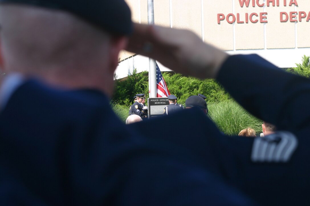 Members of the Wichita Falls Police Department Honor Guard raise the American flag May 14 as an 82nd Security Forces Squadron member gives the proper respect. Sheppard, WFPD and officers from other area law enforcement agencies honored officers killed in the line of duty during a ceremony. (U.S. Air Force photo/John Ingle)