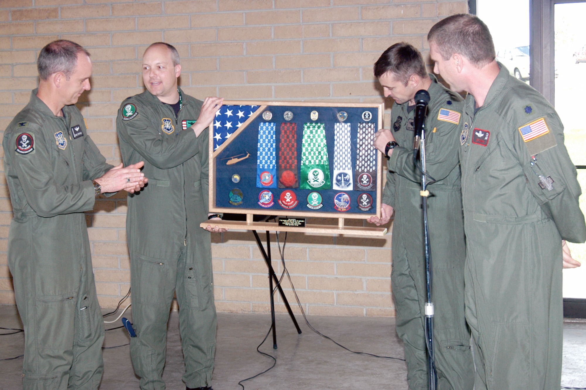 Col. Mike Fortney, 90th Operations Group commander, is presented a case with scarves and patches from all his squadrons at his farewell picnic May 3. Colonel Fortney is headed to Vandenberg Air Force Base, Calif., to work as the vice wing commander (Photo by Bernie Ernst).
