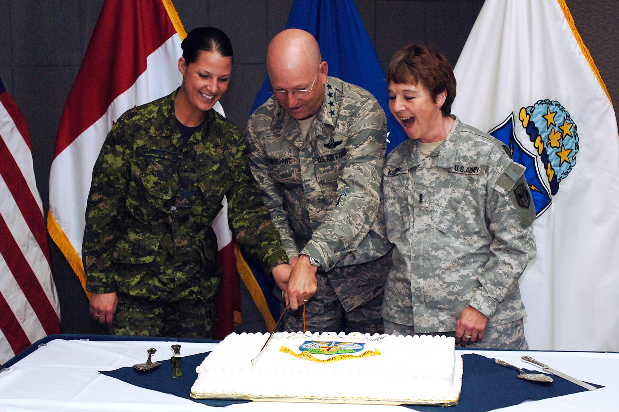 Gen. Victor E. Renuart Jr. cuts the North American Aerospace Defense Command's NORAD's birthday cake with Canadian forces Cpl. Julie Lehoux (left) and Army Chief Warrant Officer 4 Mary Koepp. Canada and the United States signed the NORAD Agreement May 12, 1958. General Renuart is the commander of NORAD and U.S. Northern Command. (U.S. Air Force photo/Petty Officer 1st Class Joaquin Juatai)
