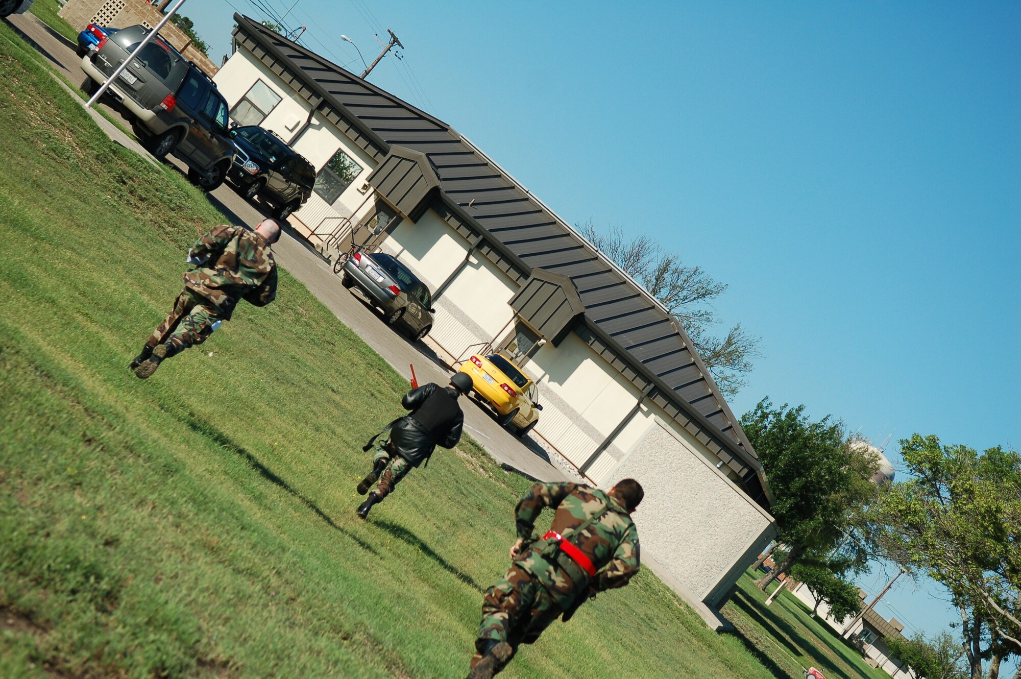 LAUGHLIN AIR FORCE BASE, Texas -- A gunman, played by 2nd Lt. Steven Benson, 47th Security Forces Squadron, runs from the Laughlin Education Center to another building, looking for victims during an exercise May 10.  Exercise Evaluation Team members followed Lieutenant Benson closely, watching the responses and reactions of those with whom he came into contact.  (U.S. Air Force photo by Staff Sgt. Austin M. May)