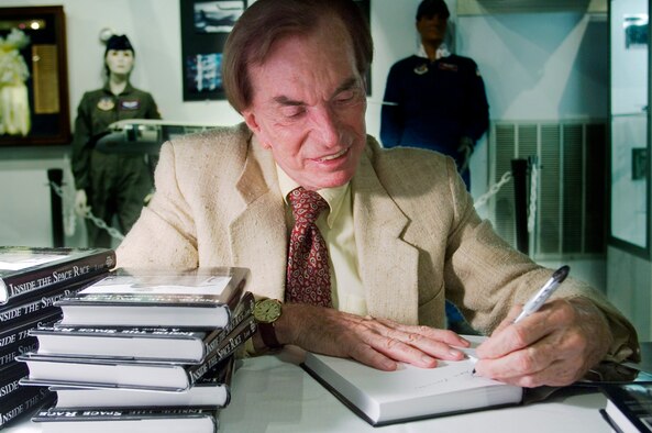 Dr. Lawrence Lamb signs his book "Inside the Space Race: a Space Surgeon's Diary" in the Brooks Heritage Foundation gift shop. Dr. Lamb was a key scientist in the United States man-in-space program and was responsible for developing medical examinations used to select astronauts,  (U.S. Air Force photo/Steve Thurow)