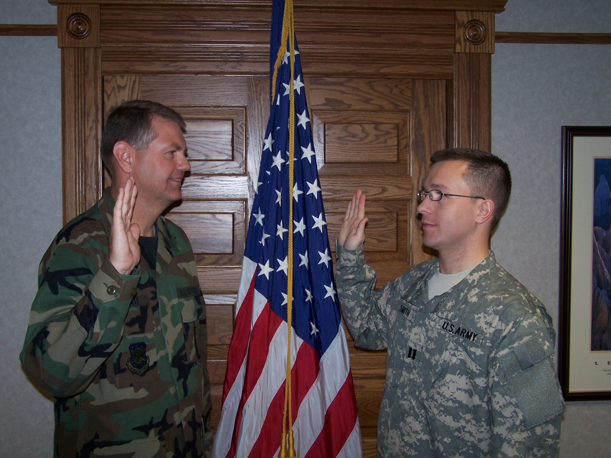 Col. L.B. Mobley, 90th Maintenance Group commander, inducts Army Capt. Scott Smith into the Army May 1. Captain Smith was with the 90th Maintenance Squadron before being selected for the blue to green program and becoming an Army intelligence officer (Photo by Master Sgt. Charles Knight).