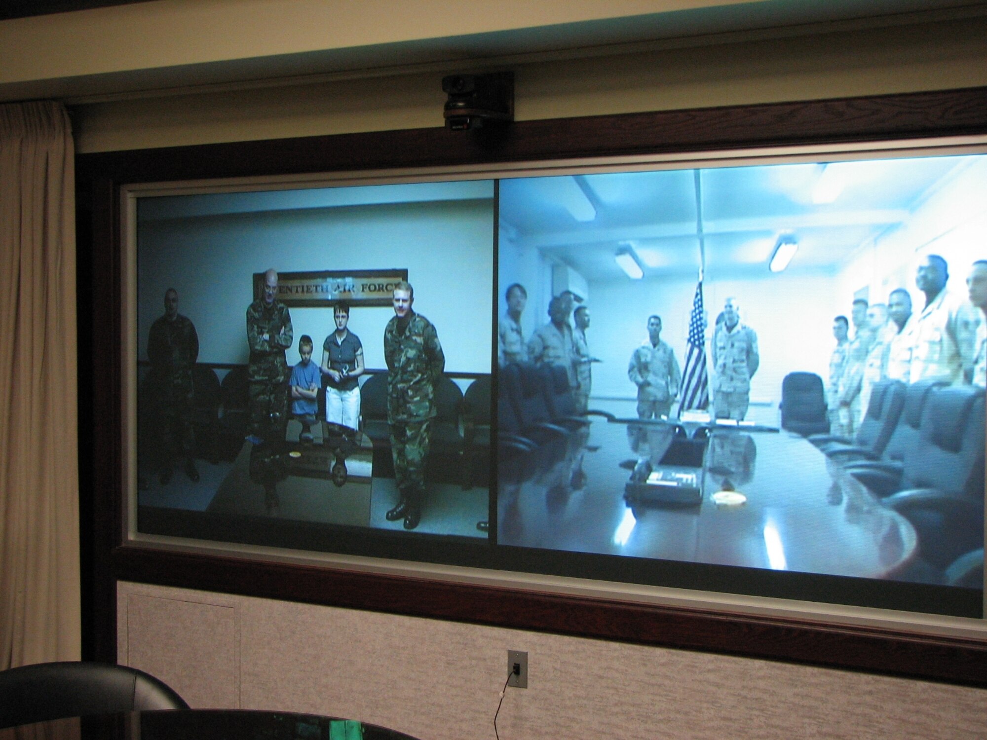 Tech. Sgt. Chris Crawford, 90th Missile Maintenance Squadron Strategic Command, talks with his wife; son; Col. L.B. Mobley, 90th Maintenance Group commander; and Lt. Col. Richard Lawrence, 90th MMXS, via video teleconference April 30. Sergeant Crawford is currently deployed to Al Udeid Air Base, Qatar. During the VTC, Sergeant Crawford was presented the 90th MMXS NCO of the Year plaque and the 90th Space Wing Communications and Information NCO of the Year plaque. He also received his promotion to technical sergeant (Photo by Tech. Sgt. Robert Ellen).