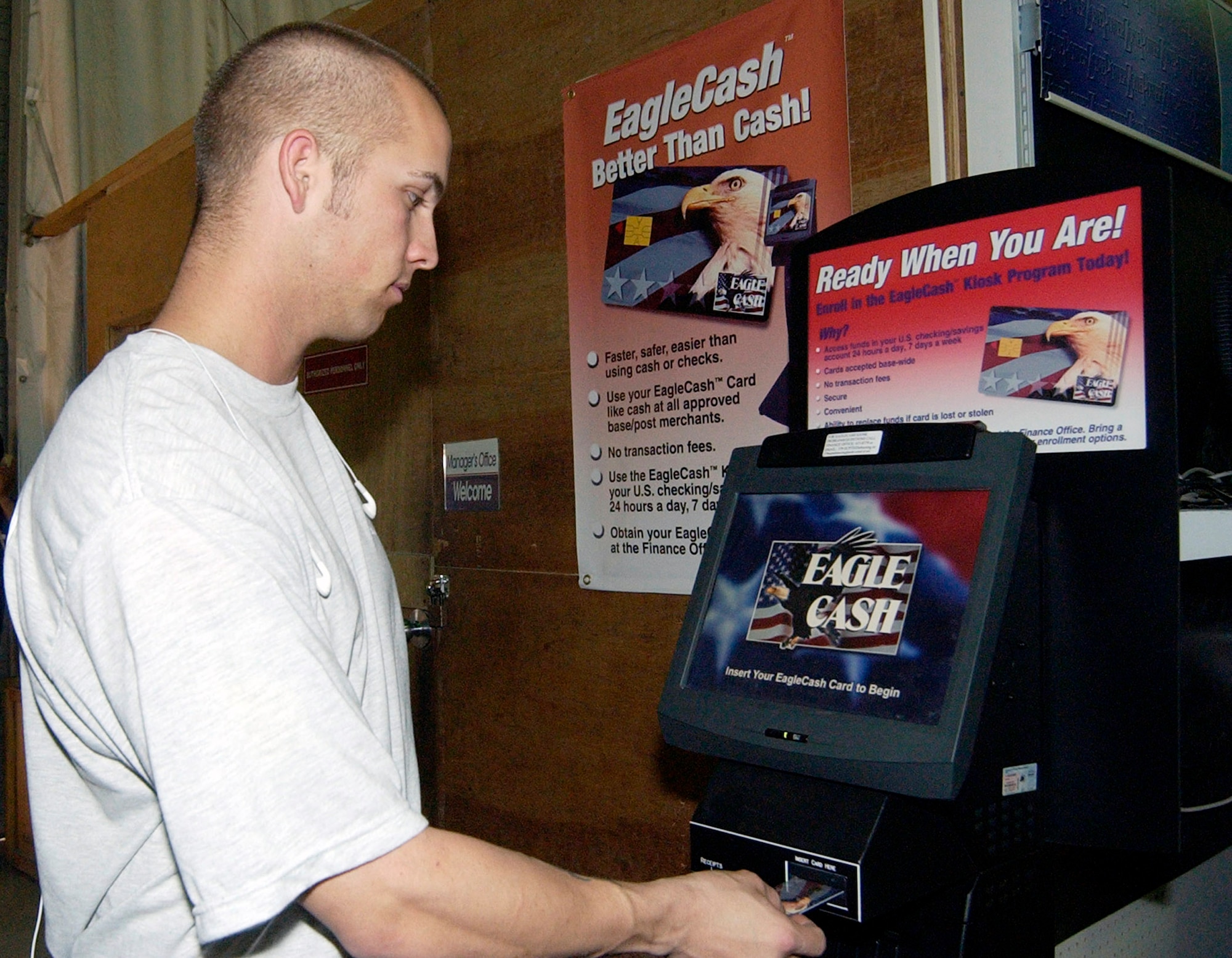 Senior Airman Mark Morris inserts his Eagle Cash card into the self-service kiosk to transfer money from his checking account to the card. A base in Southwest Asia stood up the Eagle Cash system so servicemembers in deployed locations can access their funds 24 hours a day, seven days a week. (U.S. Air Force photo/Staff Sgt. Samuel King Jr.)
                       