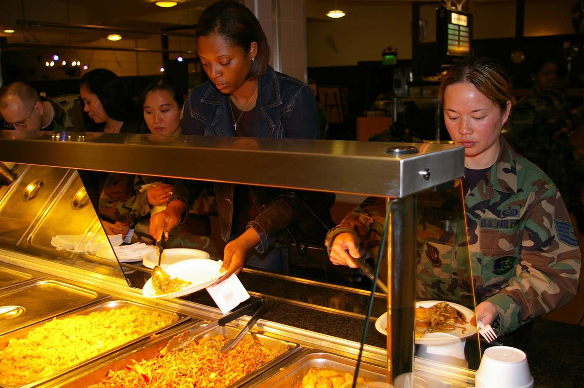 Tech. Sgt. Chi Trinh, 100th Civil Engineer Squadron, far right, and Charmaine Dunn, 501st Combat Support Wing, second right, sample food at the Gateway Dining Facility May 4 after the Asian-Pacific Heritage Month cooking demonstration. (U.S. Air Force photo by Karen Abeyasekere)