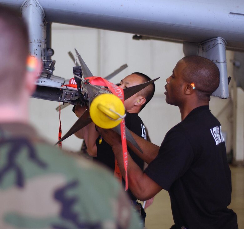 KUNSAN AIR BASE, Republic of Korea  May 12, 2007 -- An inspector (left) watches as Staff Sgts. Karlston Davis and David Hsu, assigned to the 51st Aircraft Maintenance Squadron at Osan Air Base, Republic of Korea, load an AIM-9 Sidewinder missile onto the launcher rail of an A-10 Thunderbolt II during the semi-annual 7th Air Force peninsula-wide weapons loading competition. This competition is held between Osan and Kunsan twice a year, once at each base. (U.S. Air Force photo/Senior Airman Steven Doty) 