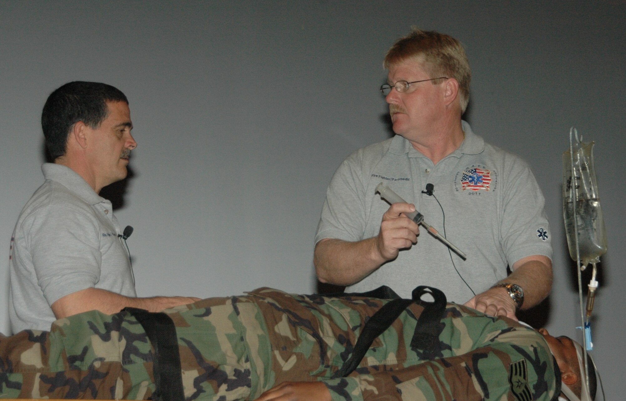 Florida firefighters Ronny Garcia (picture left) and Kevin Reed demonstrate medical techniques on Staff Sgt. Talmage Williams, 28th Munitions Squadron munitions storage crew chief, during a SAFE brief April 27 at the base theater.  SAFE features members of the medical and law enforcement  community who share their no-hold barred and grittily honest experiences with audiences around the world. (U.S. Air Force photo/Tech. Sgt. Todd Wivell)