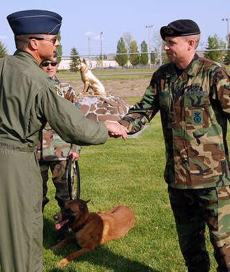 FAIRCHILD AIR FORCE BASE, Wash. – Tech. Sgt. Charles Wilds, 92nd Security Forces Squadron NCOIC of the military working dog section, receives a coin from Col. Scott Hanson, 92nd Air Refueling Wing commander after a military working dog demonstration. (U.S. Air Force photo/ Tech. Sgt. Larry Carpenter)  