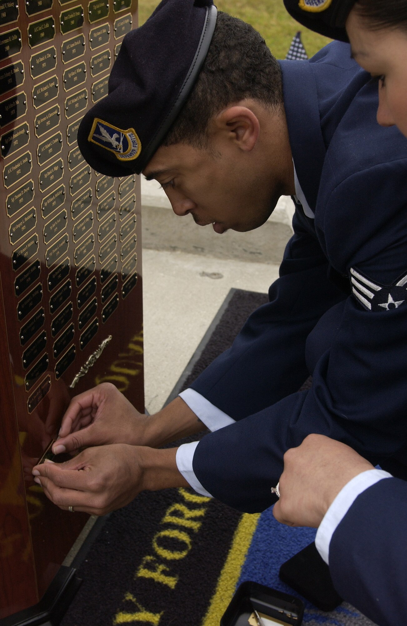 Senior Airman James Banks pins the name of Cpl. David Williams to a security forces memorial at Vandenberg on May 14.  The security forces memorial reflects names of fallen Airmen in the security forces career field who were killed in the line of duty.  Cpl. Williams of Tamaqua Pennsylvania died March 4, 1951 in the line of duty while performing base security at Offut Air Force Base, NE.   (U.S. Air Force photo by Airman 1st Class Adam Guy)