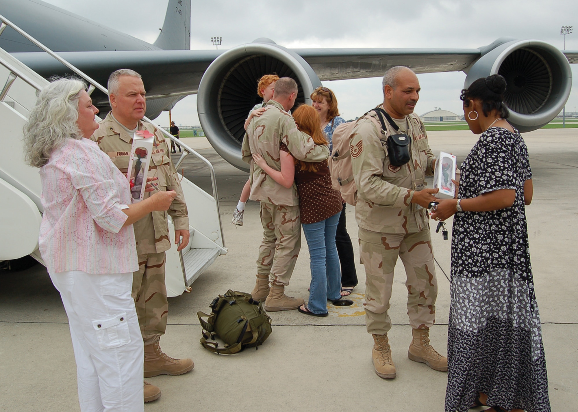 Brigadier General John Fobian (left), 433rd Airlift Wing Commander, is welcomed home by his wife, Kim, and members of the Alamo Wing on May 2, 2007. Tech. Sgt. Raffael Dickerson (right) and Maj. Mike Nelson, also from the 433rd AW, are also greeted by family on thier arrival. General Fobian served as the Director of Mobility Forces, Major Nelson served as General Fobian's executive officer and Sergeant Dickerson as his administrative assistant during thier deployment to the Combined Air Operations Center in Southwest Asia. (U.S. Air Force Photo/ Master Sgt. Collen McGee)
