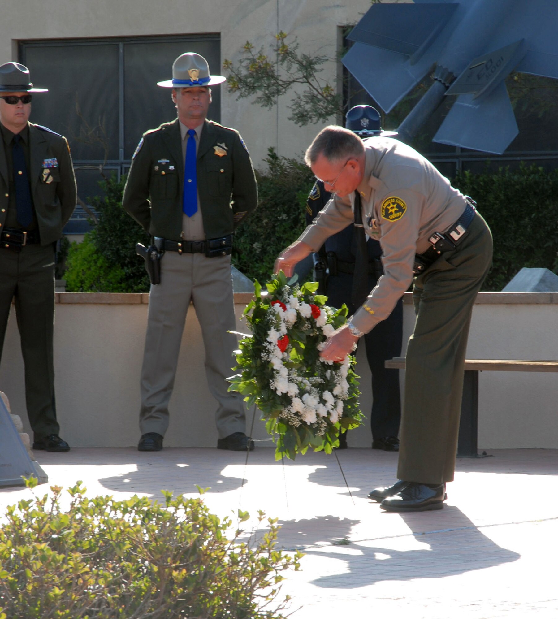 A local police officer places a rose on a wreath Tuesday to honor both Edwards and local police officers who have been killed in the line of duty. (Photo by Airman Mike Young)