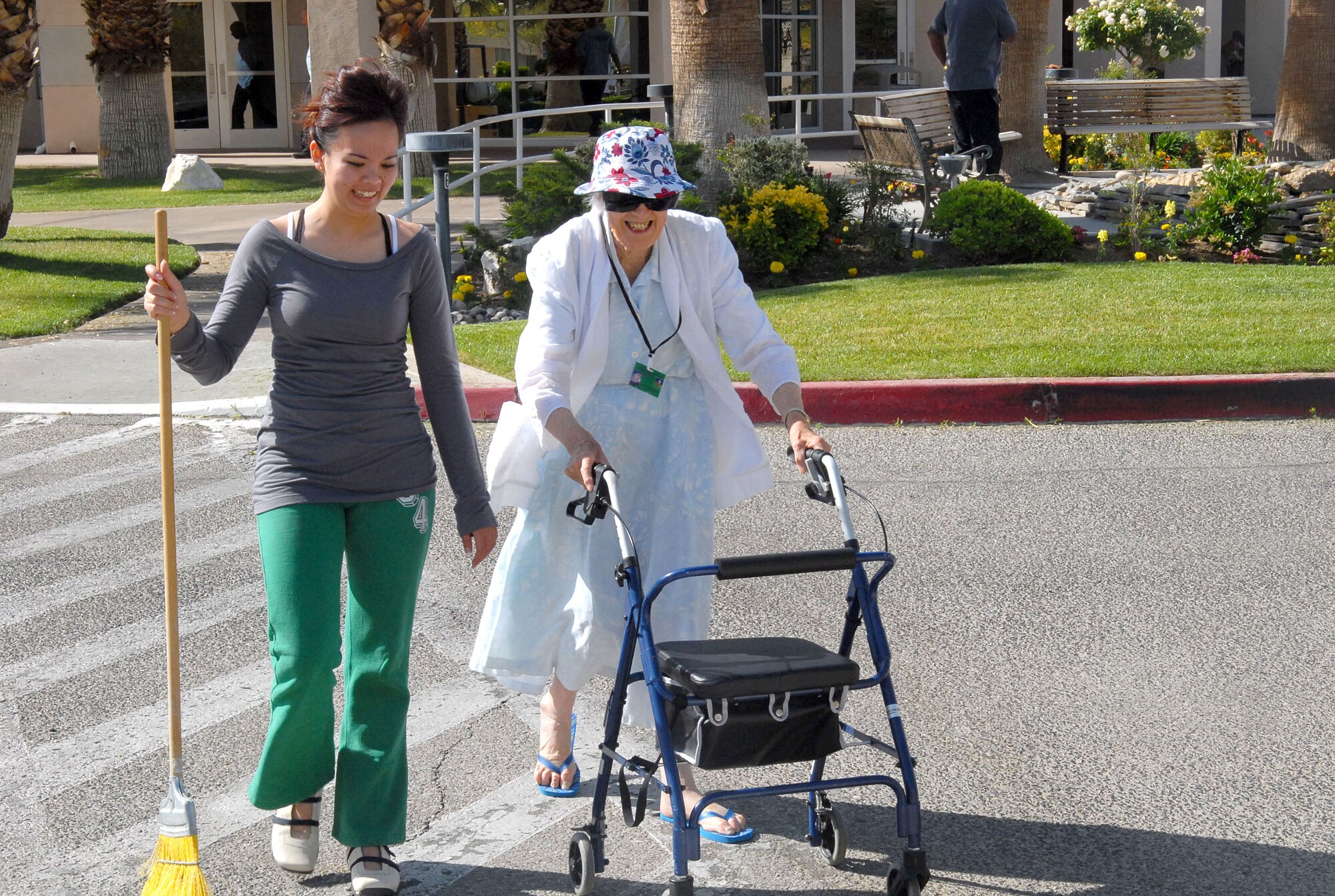 Airman 1st Class Deencel Tan, 95th Mission Support and Services Squadron outbound assignments counselor, walks with Maybelle Hastings at the Barstow Veterans Home during the Top-3 veterans home visit Saturday. (Photo by Senior Airman Jason Hernandez)