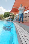 Phillip Sparks, 12th Services Division maintenance worker, skims the center pool May 8 in preparation for the summer swimming season. Pool passes are on sale at the Randolph Information, Tickets and Travel office, Building 897. The center pool opens May 26. (U.S. Air Force photo by Rich McFadden)